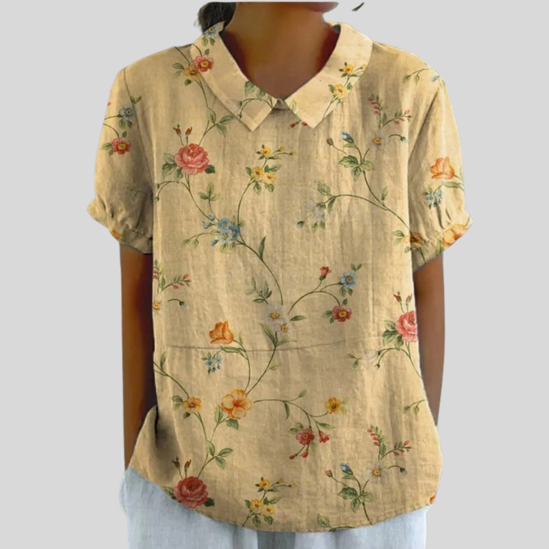 A woman wearing a flattering floral top with a polo collar, looking feminine and groomed.