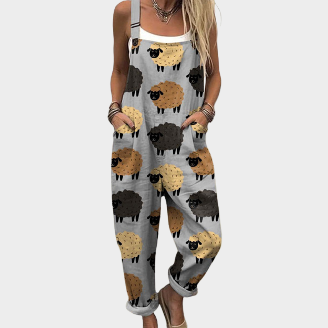 Woman wearing soft grey overalls printed with cheerful little sheep in black, brown and cream