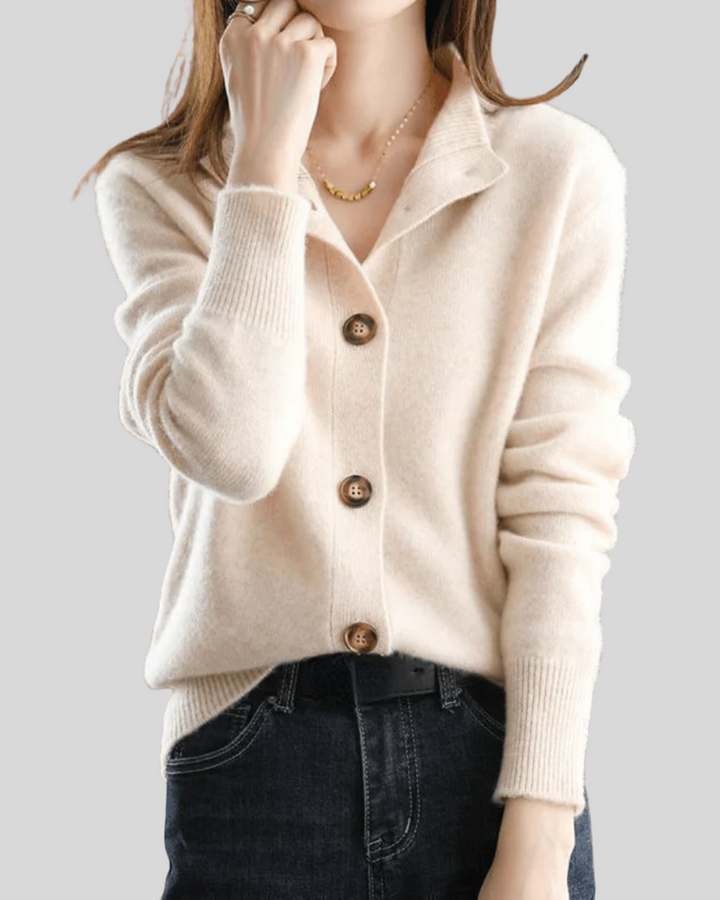 A woman wearing a beige retro button cardigan layered over a dress, warm and elegant.