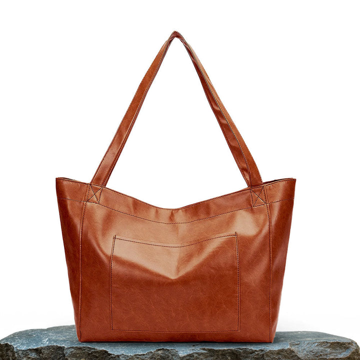A woman wearing a vintage-style shoulder bag while walking through a weekend market.