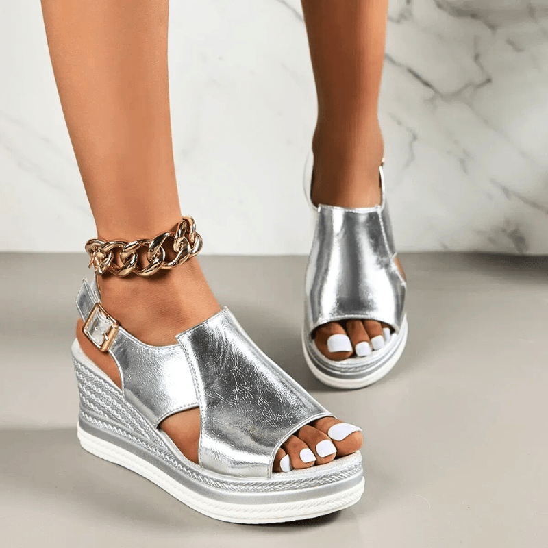 A woman wearing gold metallic sandals with a cushioned insole and wide, supportive fit.