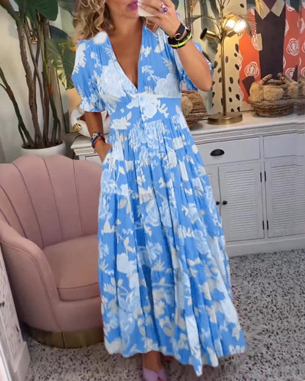 A woman wearing the Dawn bold floral maxi dress with a flowing full-length skirt at a garden gathering.
