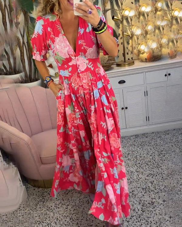 A woman wearing the Dawn bold floral maxi dress with a flowing full-length skirt at a garden gathering.