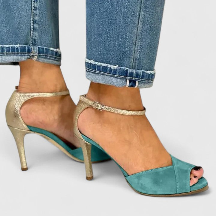A woman wearing green open-toe heels, standing out in a striking occasion outfit.
