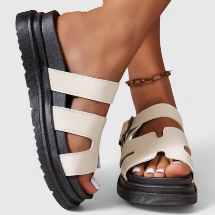 A woman in cream elegant sandals standing gracefully, feet supported and at ease.