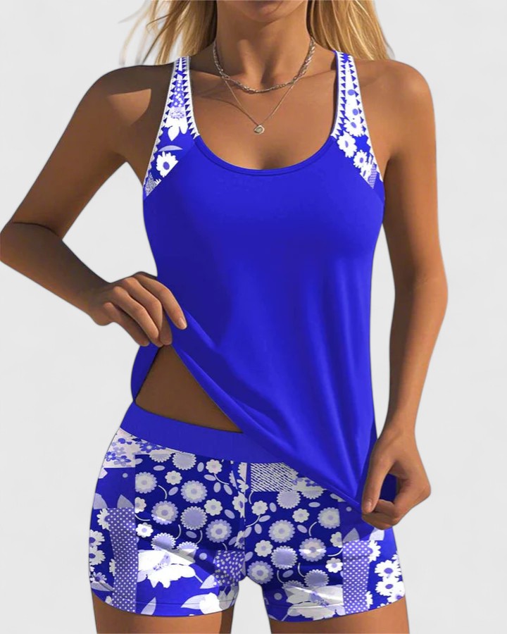 A woman wearing a blue tankini set with a loose tank top and matching floral-print shorts.