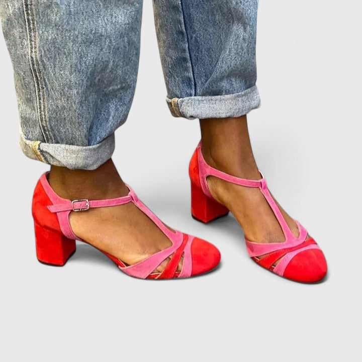 A woman wearing berry red heels with an ankle strap, stepping out in a confident evening look.