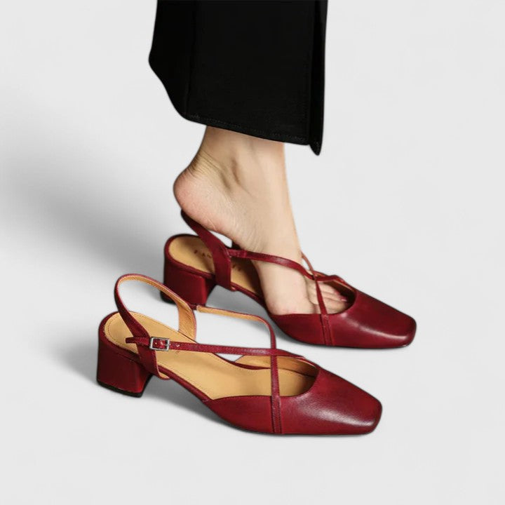 Burgundy closed square-toe flats with criss-cross instep straps and a buckled slingback.