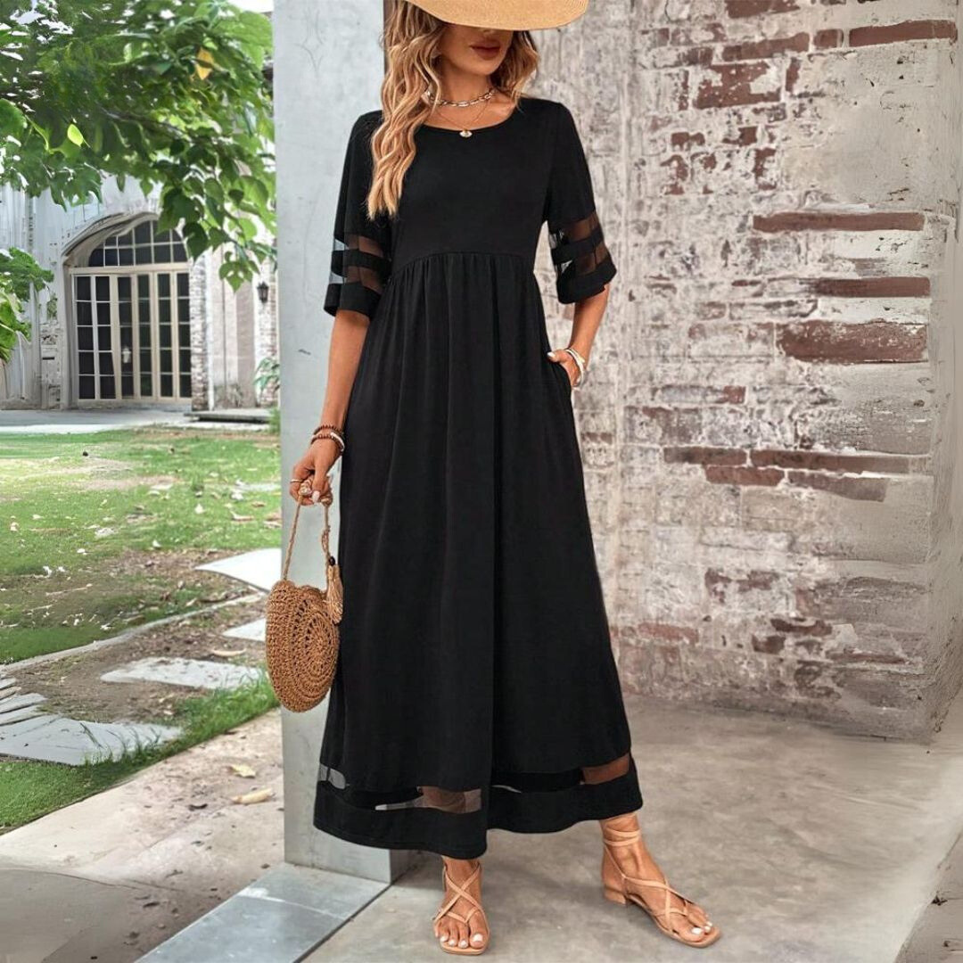 Woman wearing the Colleen™ empire waist midi dress with a flowing skirt and round neckline at a family gathering.