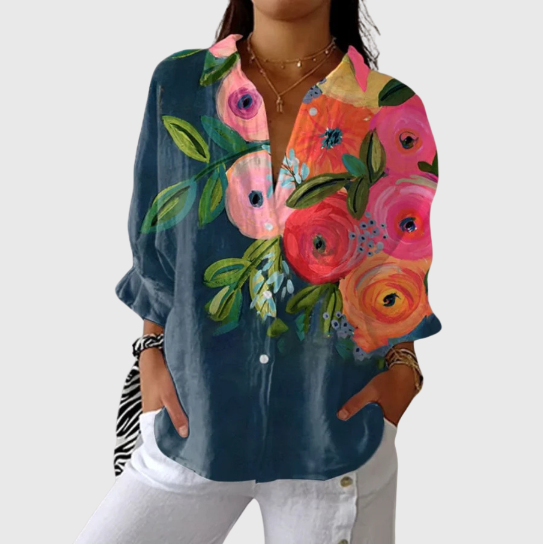 A woman wearing a light, colourful printed blouse with a relaxed, flowing cut, looking cheerful and comfortable.