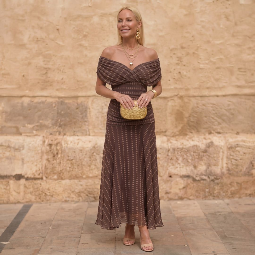 A woman wearing a light brown dress with a modern geometric print at a daytime outing.