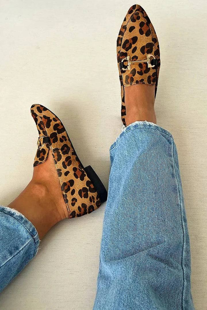 A woman wearing leopard print slip-on loafers, styled for an easy day in the city.