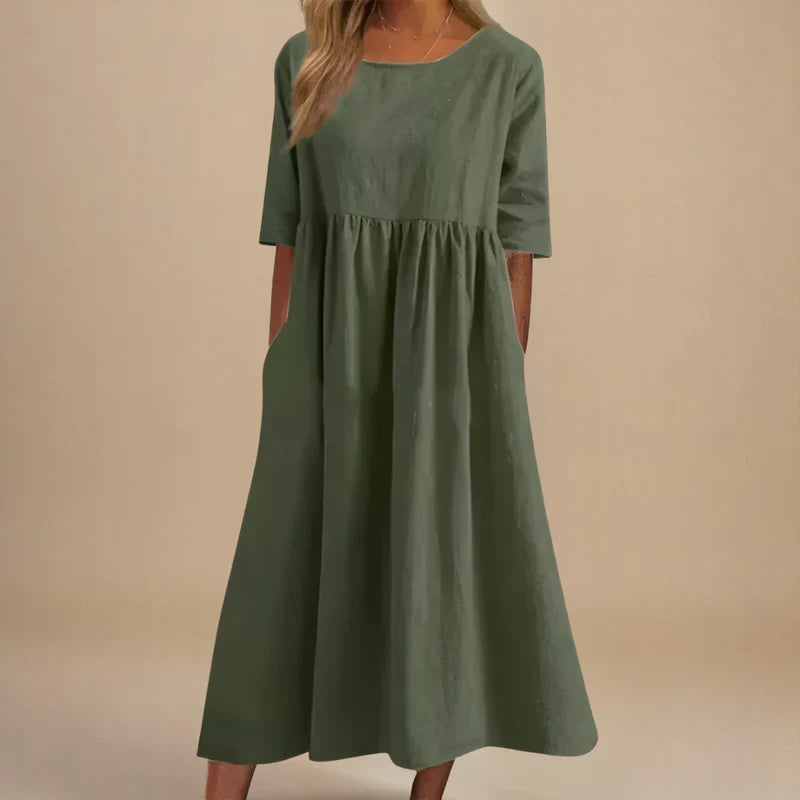 A woman wearing the Shannon flowing day dress with a gathered waist and elbow-length sleeves.