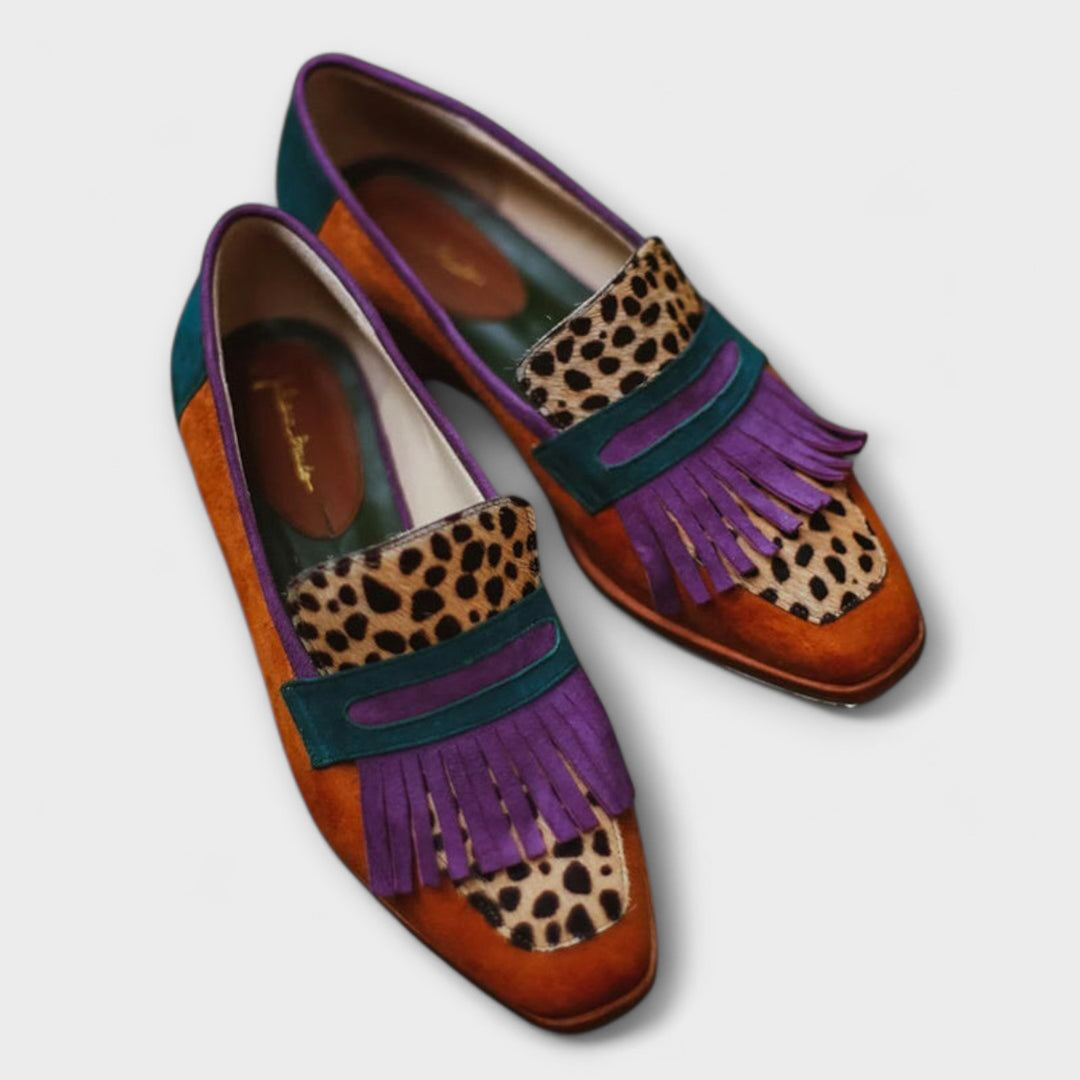 A woman's colourful fringed loafers in rust, teal and purple with leopard-spot panels and a purple kiltie fringe.