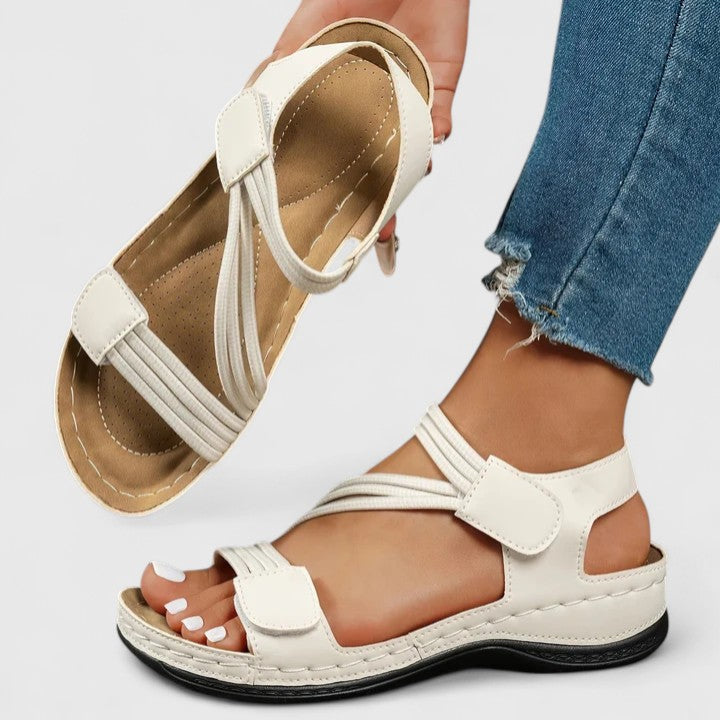 A woman wearing soft adjustable comfort sandals with a summer outfit, looking relaxed and content.