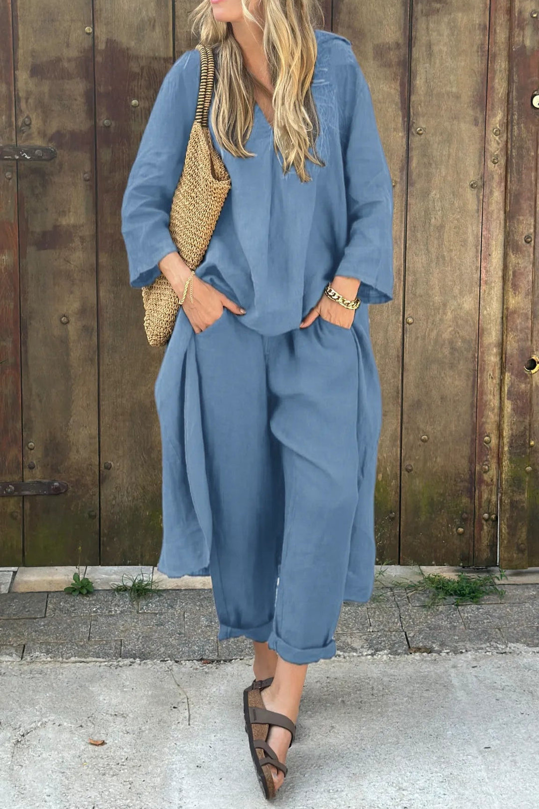 A woman wearing a blue asymmetric tunic with wide-leg pants