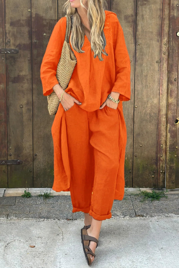 A woman wearing a blue asymmetric tunic with wide-leg pants