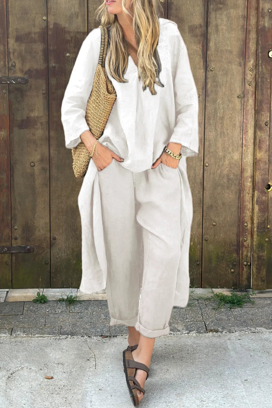 A woman wearing a blue asymmetric tunic with wide-leg pants