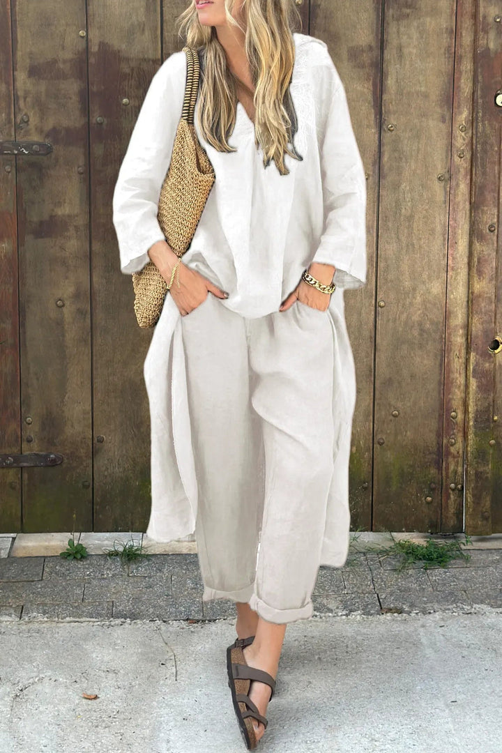 A woman wearing a blue asymmetric tunic with wide-leg pants
