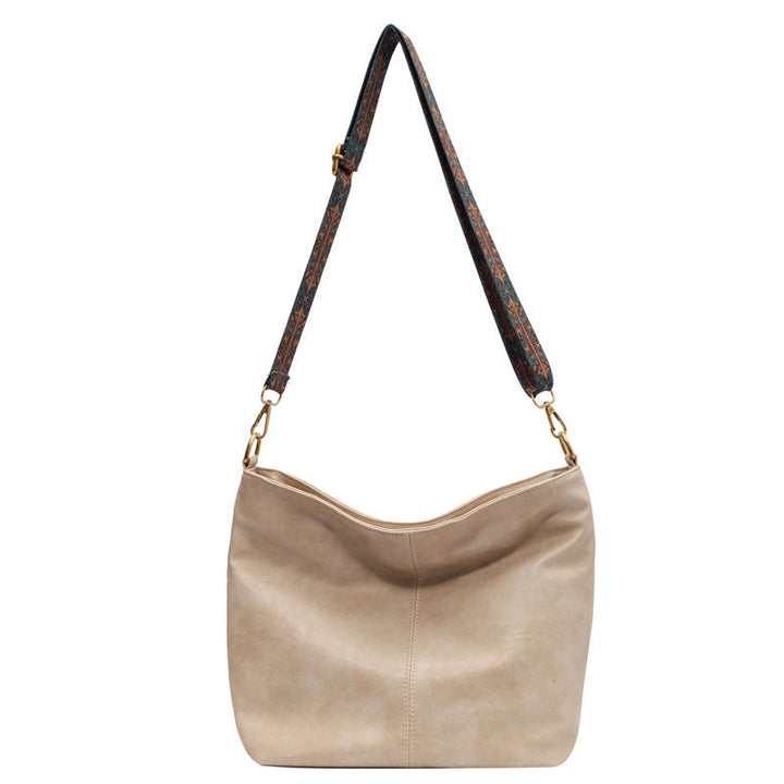 A woman carrying a vintage-style bag with a shoulder strap on a day out