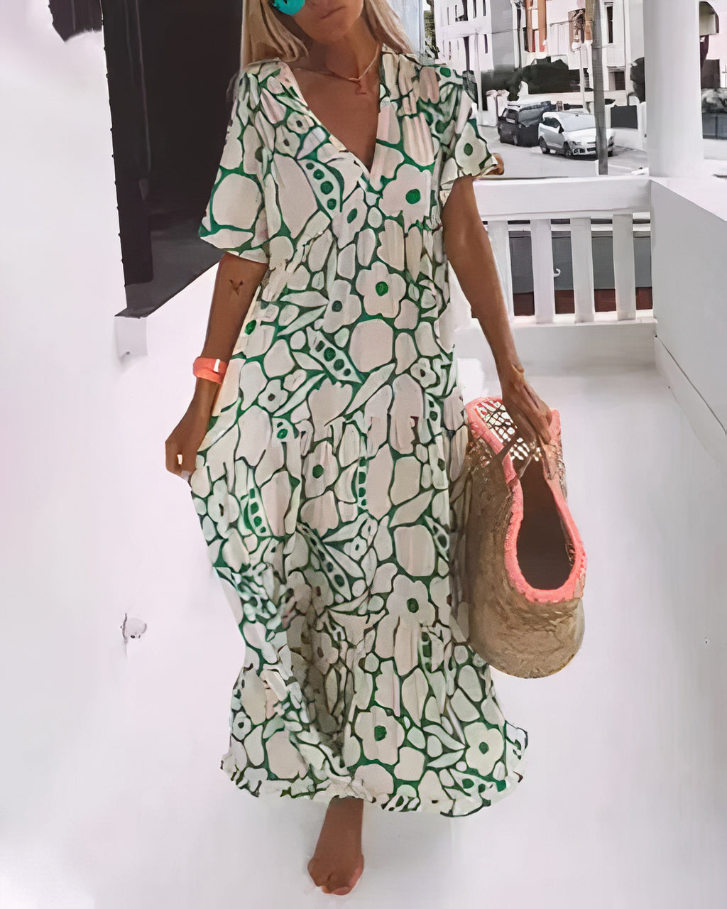 Woman wearing a flowing floral midi dress with a V-neckline while walking outdoors.