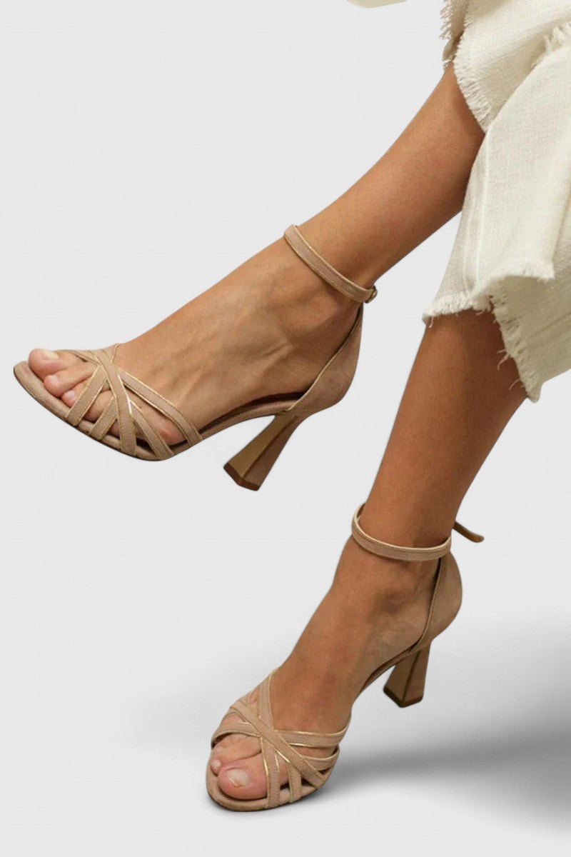 A woman in nude strappy heeled sandals with a slim ankle strap, ready for a day that runs into evening.