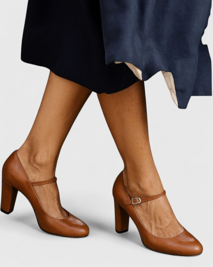 A woman wearing brown block heels with an ankle strap, walking confidently through her day.