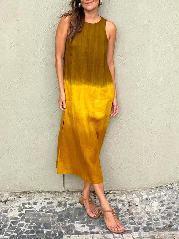 A woman wearing a sleeveless midi dress with a soft ombré colour gradient, walking outdoors.