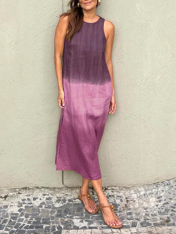 A woman wearing a sleeveless midi dress with a soft ombré colour gradient, walking outdoors.