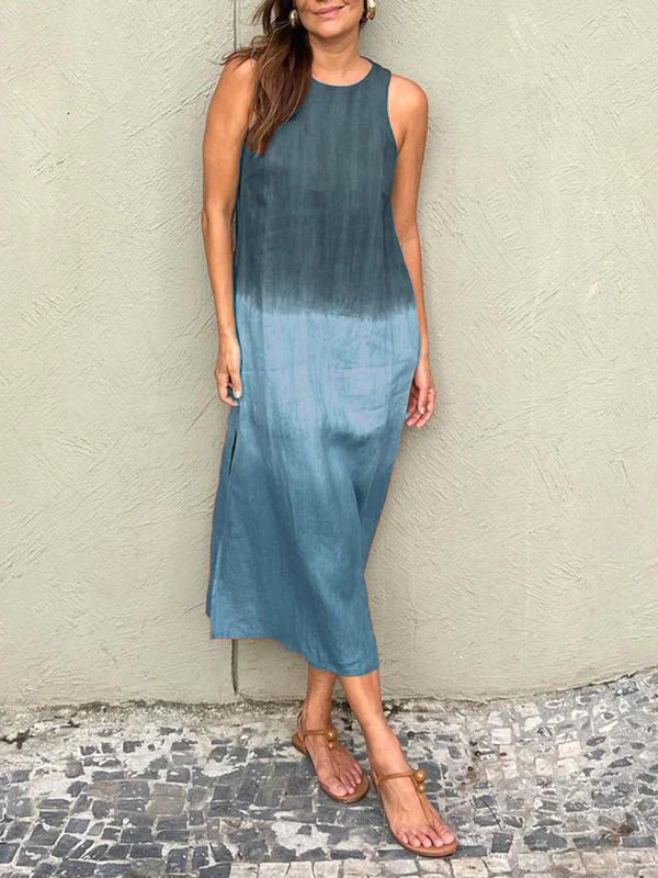 A woman wearing a sleeveless midi dress with a soft ombré colour gradient, walking outdoors.