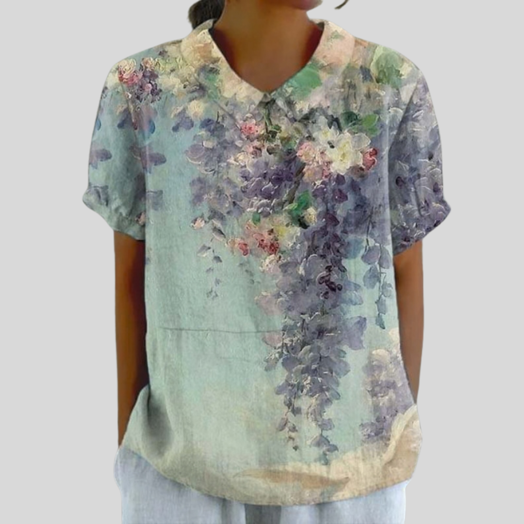 A woman wearing a refined floral top with an elegant collar while out for coffee with friends.