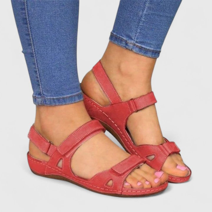 A woman walking through town in tan flat comfort sandals, relaxed and at ease.
