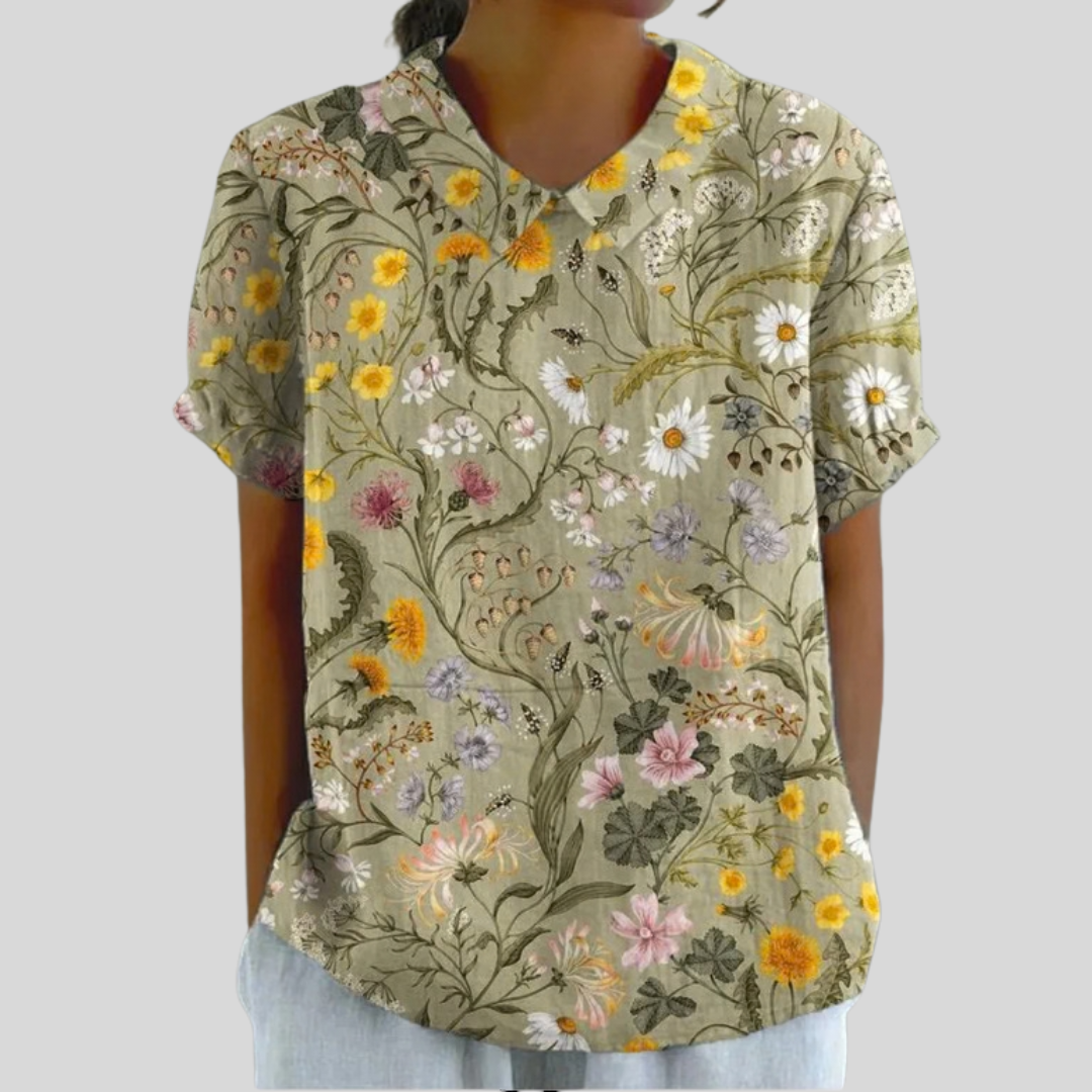 A woman wearing a timeless floral top with an elegant collar and gently flowing shape.