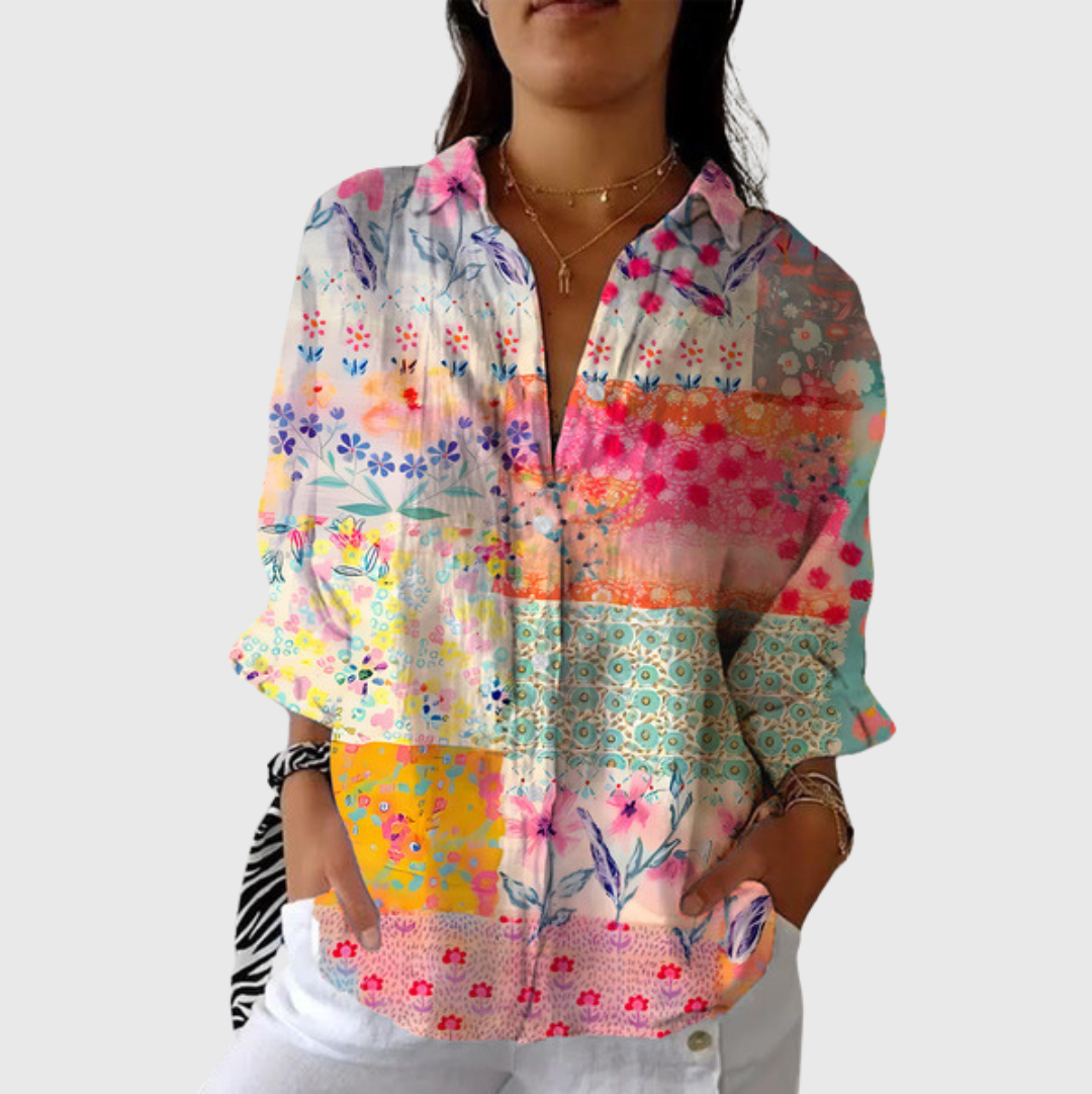 A woman wearing a relaxed colourful printed blouse with an elegant button front, styled with jeans for a comfortable outing.