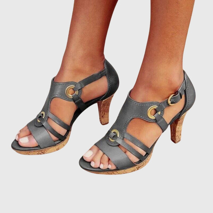 A woman in supportive heeled sandals standing comfortably at a summer event.