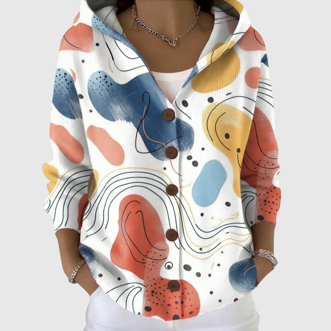 A woman wearing a soft hooded cardigan open over a top, relaxed and comfortable on a mild day