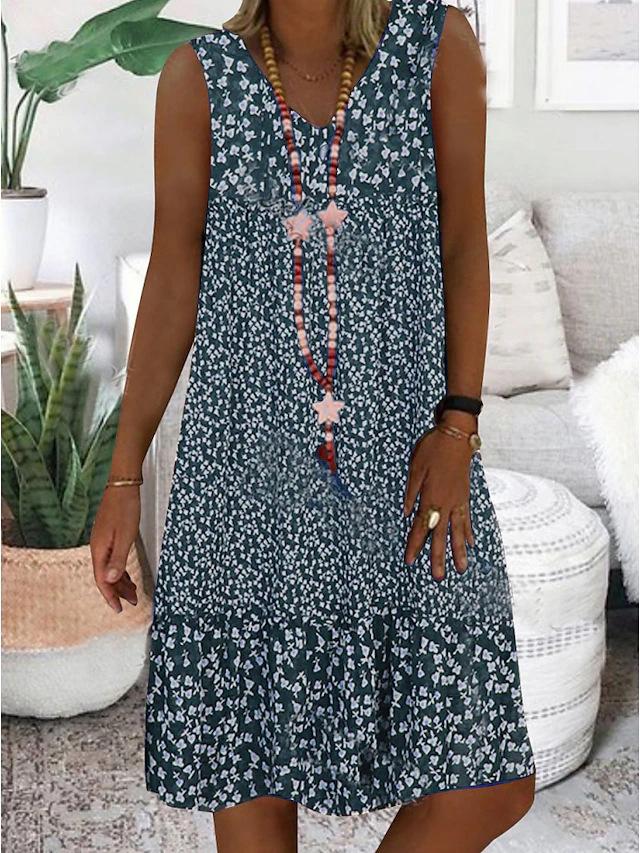 A woman wearing the Wendy sleeveless V-neck floral dress on a sunny day outdoors.