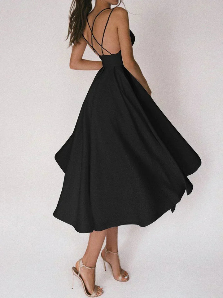 Woman at a summer celebration wearing the Beth minimalist maxi dress with fine double straps and a floating skirt.