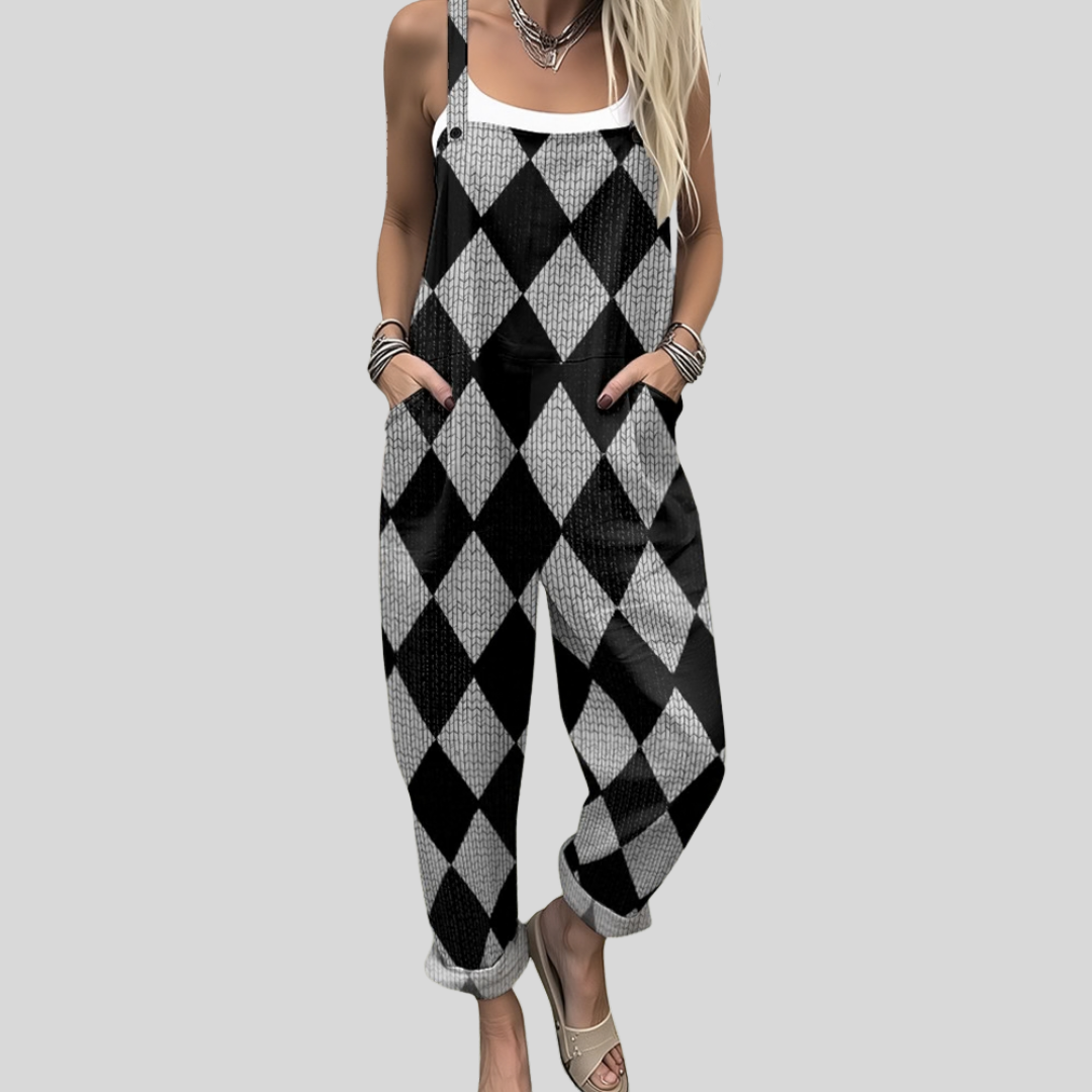 A woman wearing overalls in a striking black-and-white harlequin diamond pattern, with adjustable straps.