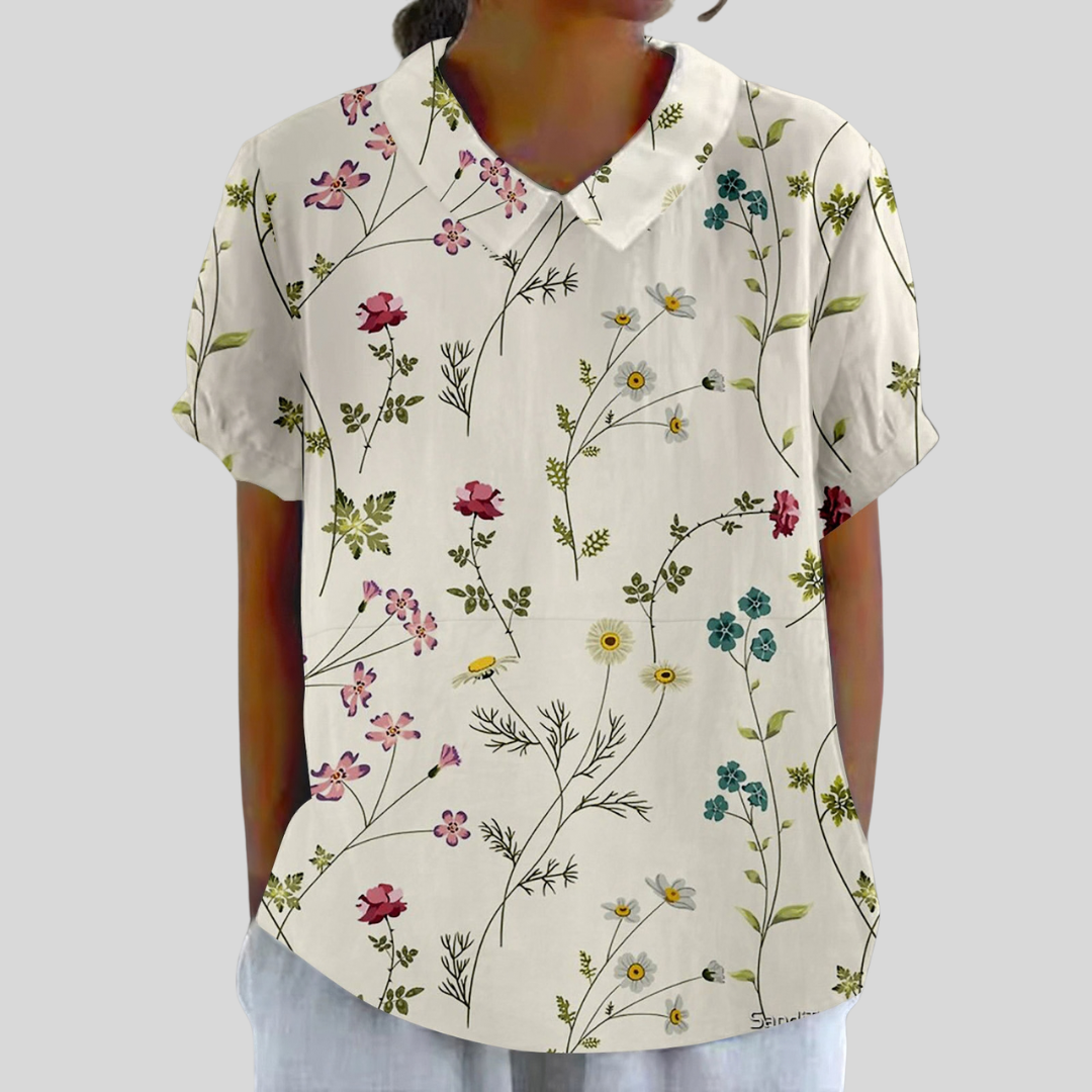 A woman wearing a timeless floral top with a refined polo collar, dressed for a day in town.