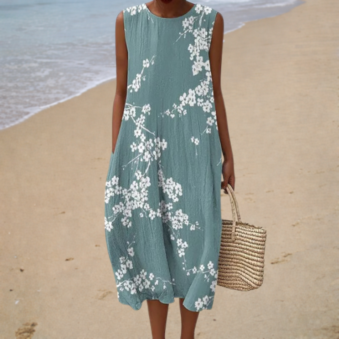 A woman in a sleeveless, flowing summer dress that drapes gently as she enjoys a warm afternoon.