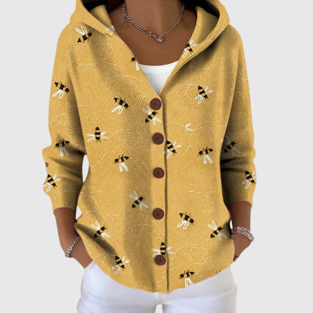 A woman wearing a soft hooded cardigan closed over a fine top, relaxed on a cool day