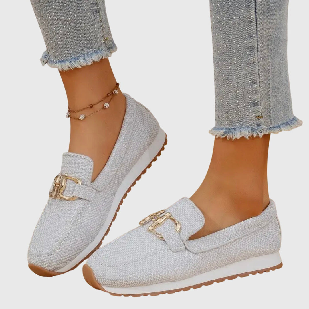 A woman in smart-casual orthopaedic loafer sneakers with a subtle golden detail.