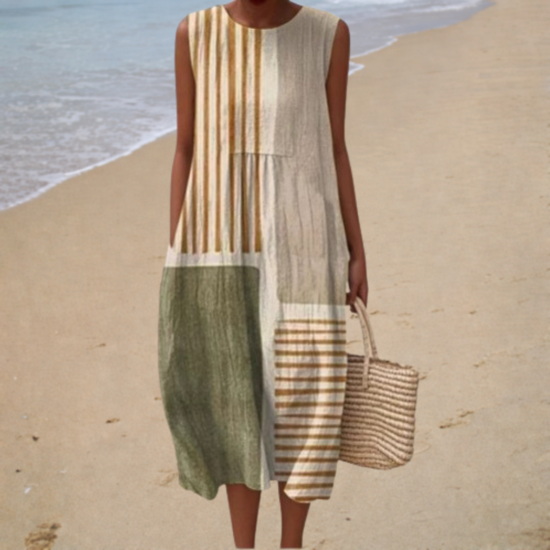 A woman wearing a loose sleeveless printed summer dress, standing relaxed in warm sunshine.