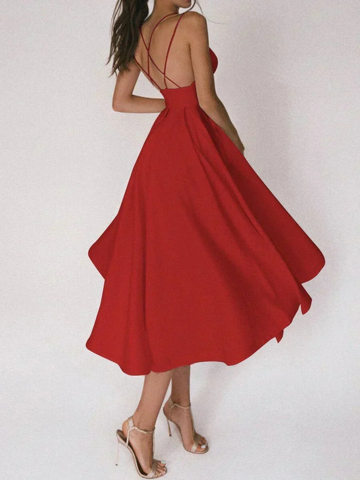 Woman at a summer celebration wearing the Beth minimalist maxi dress with fine double straps and a floating skirt.