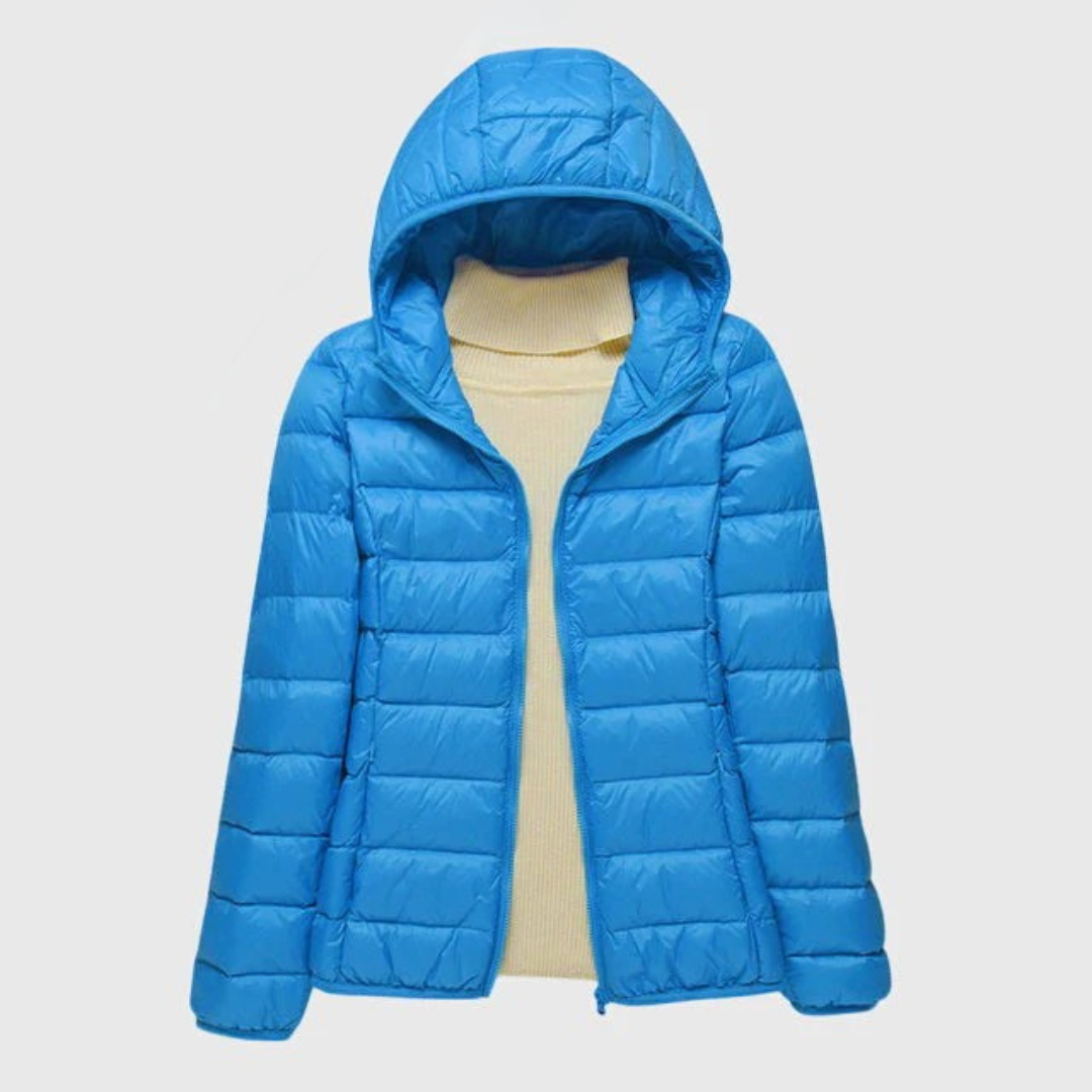 A woman wearing a lightweight padded jacket with a hood, outdoors on a cool day