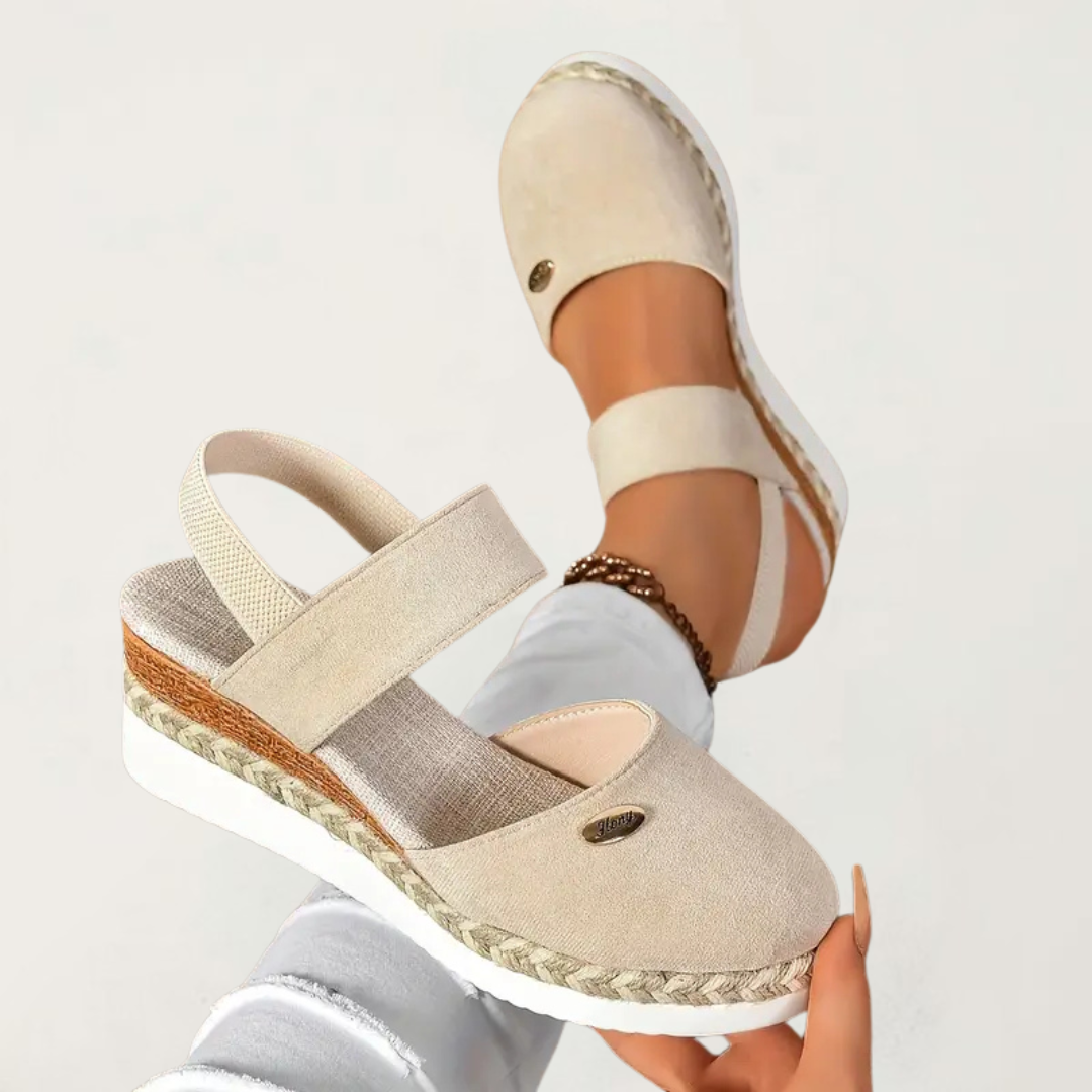 Black closed-toe wedge espadrilles with a wide stretch strap and a braided-trim platform wedge.