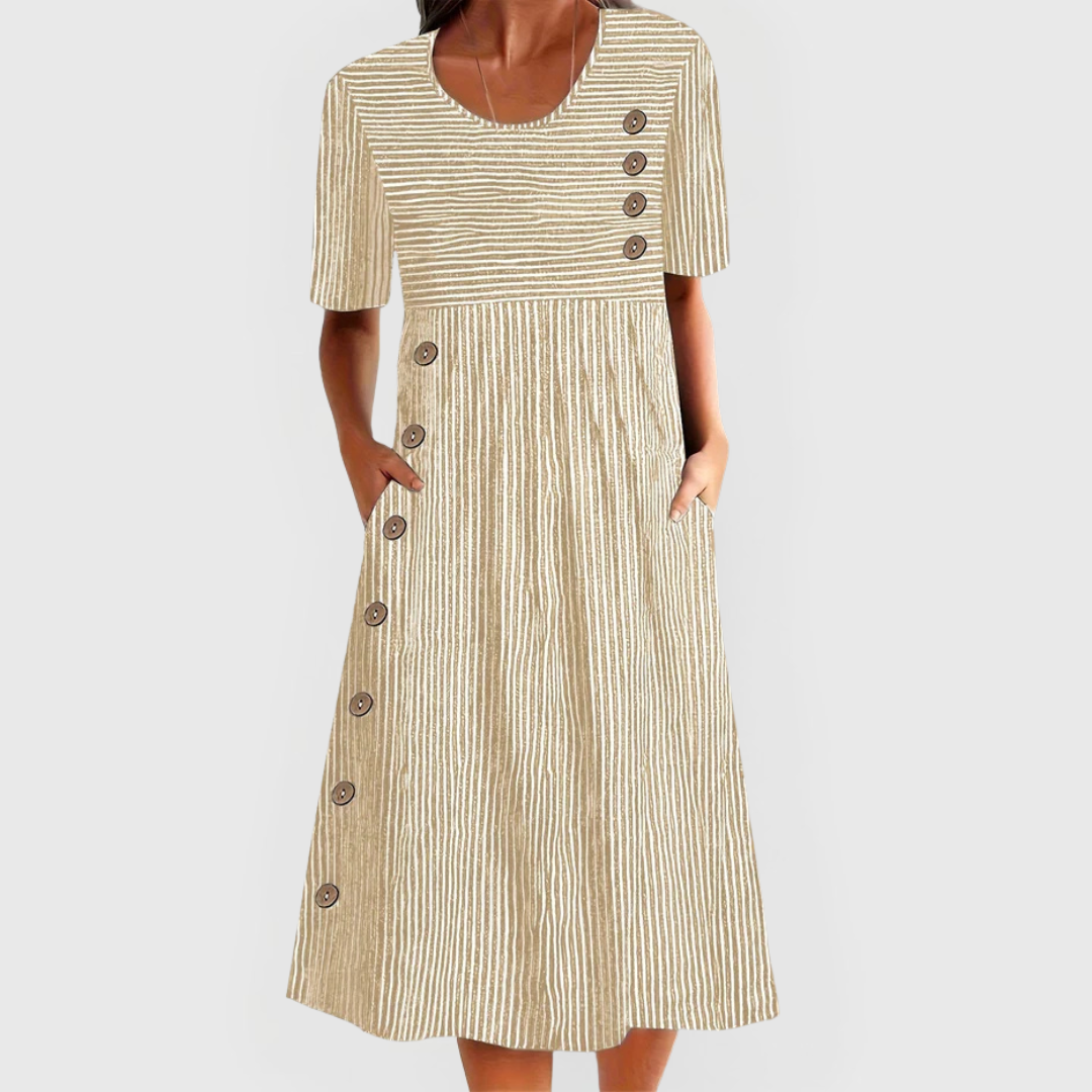 A woman wearing the Helen striped midi dress with button details, standing outdoors on a bright day.