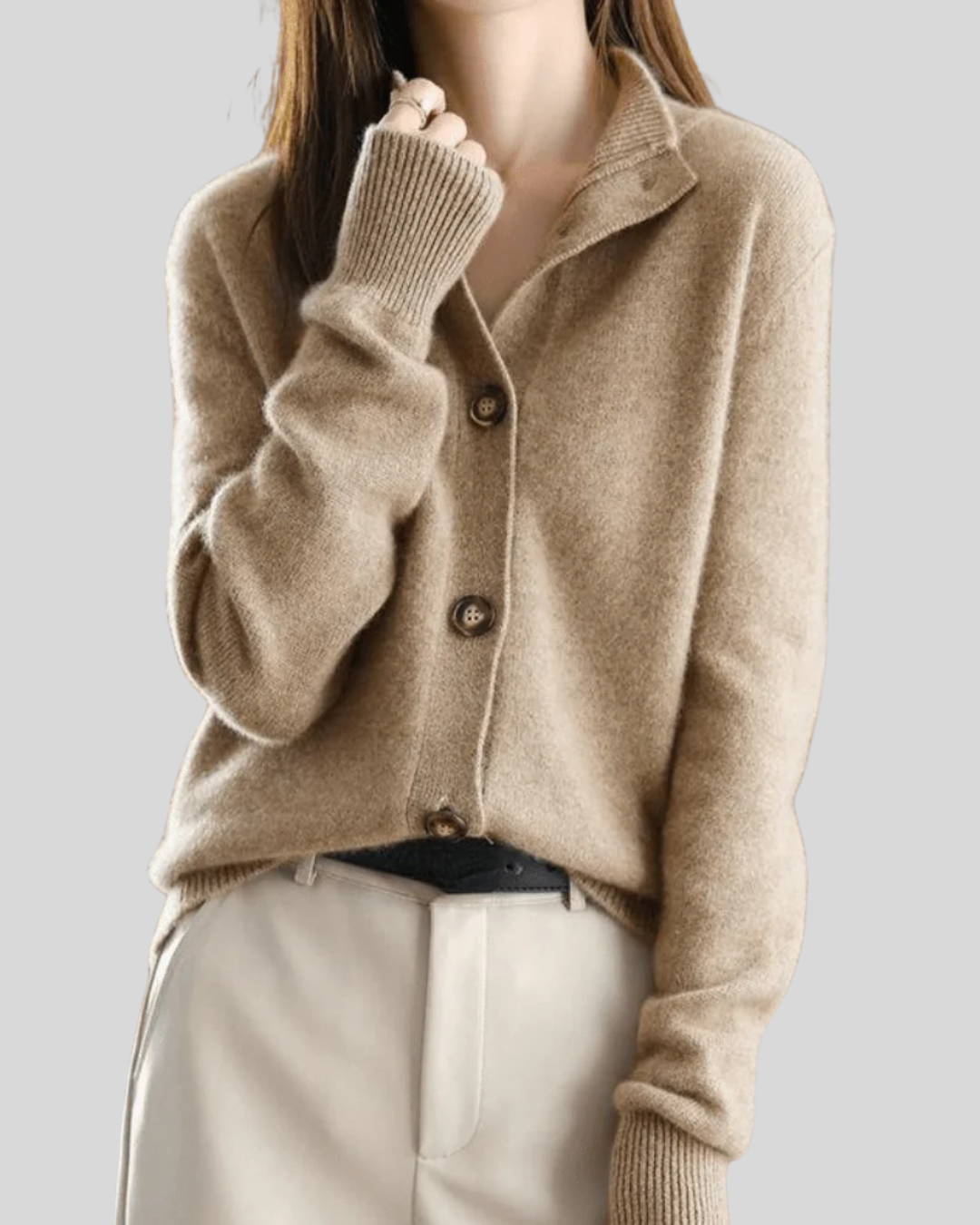 A woman wearing a beige retro button cardigan layered over a dress, warm and elegant.