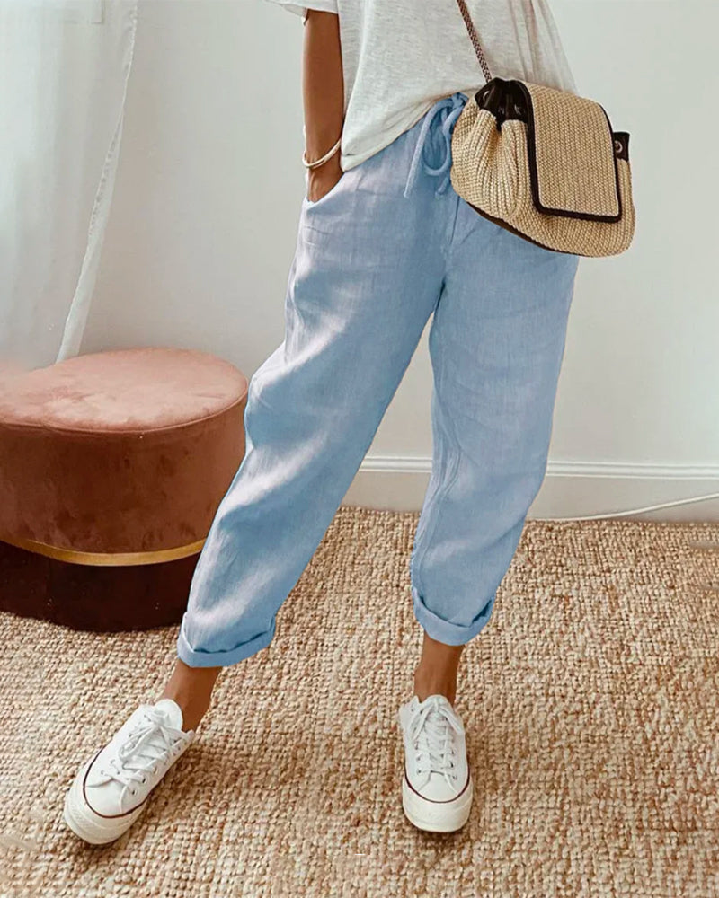 A woman wearing flowing elegant pants with a soft elastic waist and deep pockets.